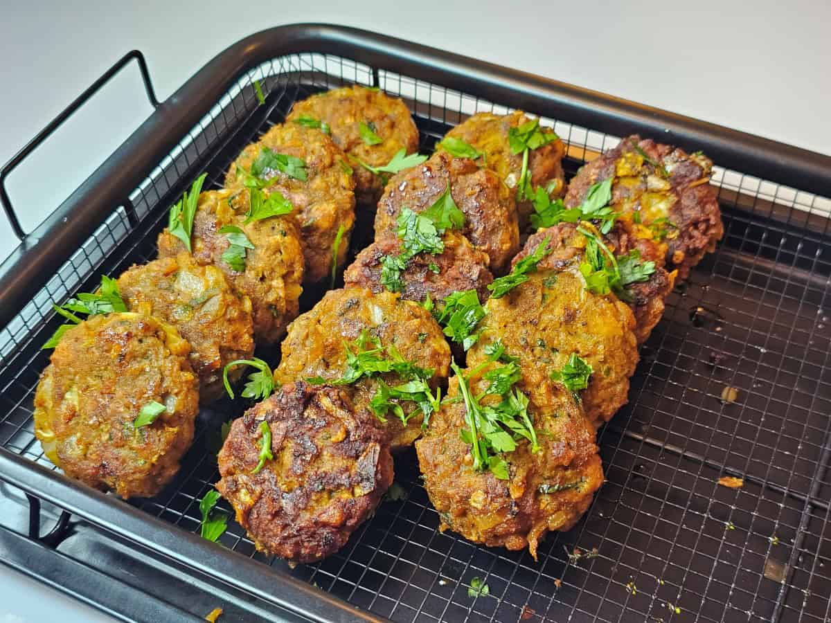 קציצות שווארמה טבעוניות על בסיס ChickenFree, מתובלות עם פטרוזיליה טרייה, מסודרות על סלסלה מלבנית שחורה.