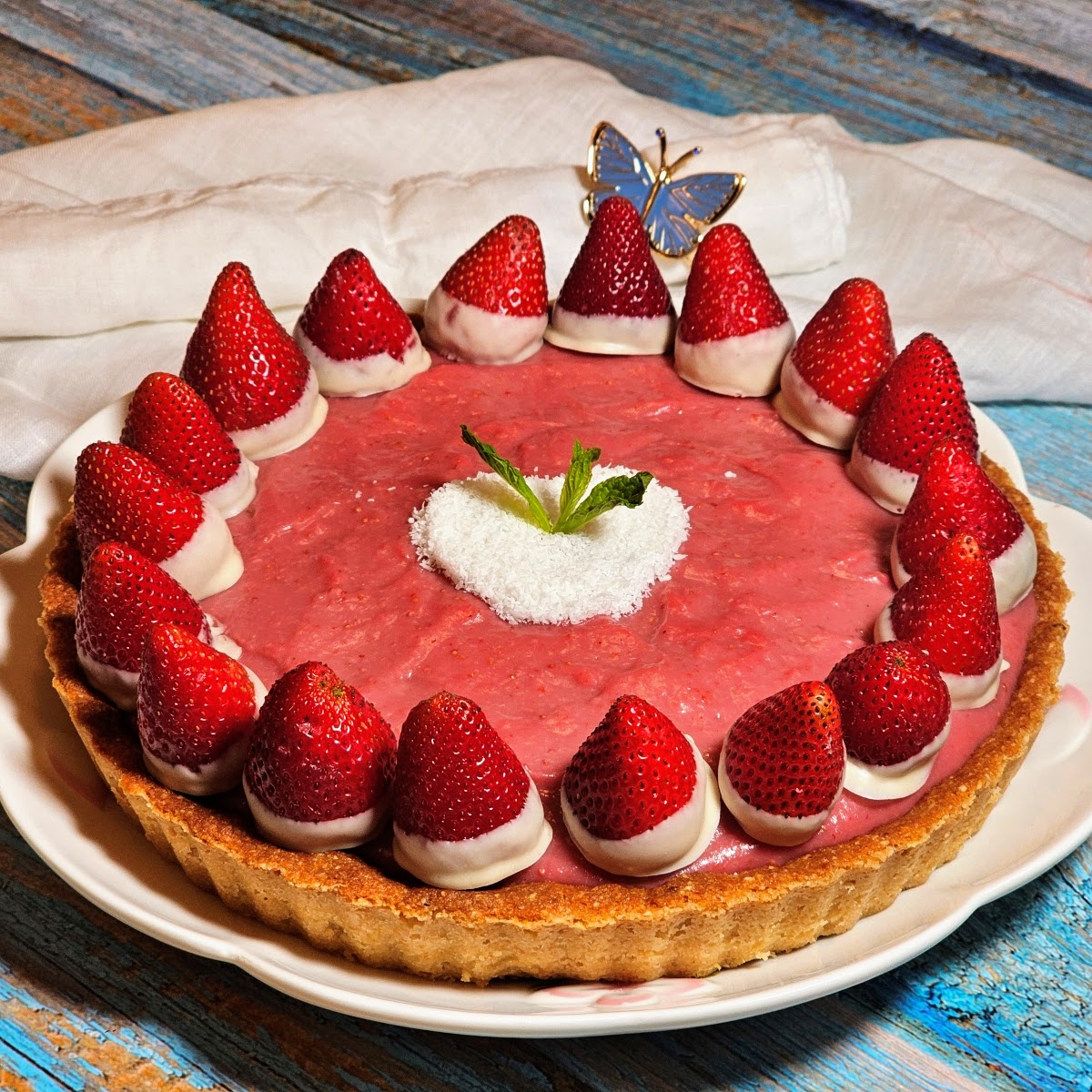 Gluten-free vegan strawberry tart decorated with whole strawberries dipped in white chocolate